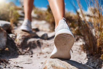 Image showing Shoes, hiking and fitness with a woman closeup walking up a mountain trail for exercise, cardio or adventure. Nature, training and feet with a female hiker stepping on a rock while outdoor for a walk