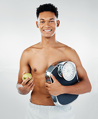 Image showing Apple, man and scale for health, fitness and diet in studio against white background mockup for weight loss. Fruit, training and wellness model with black man happy, smile and relax with nutrition