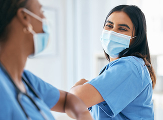Image showing Covid, women and doctors elbow greeting in surgical mask at hospital or clinic during the pandemic. Teamwork, healthcare worker and medical professional with protection from virus for doctor or nurse