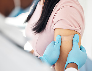 Image showing Covid, vaccine and bandaid with hands of doctor and woman arm for medicine, medical and consulting. Wellness, first aid and healthcare with nurse and patient for virus, flu and treatment injection