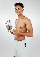 Image showing Fitness, apple and man drinking water in studio after training, cardio workout and exercise for body wellness. Lifestyle, fruit and healthy young athlete or happy personal trainer on a vegan diet