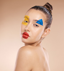 Image showing Beauty, makeup and clown by woman in studio for fun, art and creative expression against a brown background with mockup. Face, portrait and pigment cosmetic product with girl model circus aesthetic