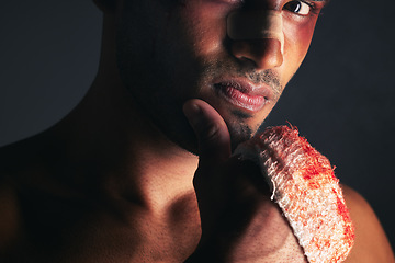 Image showing Fight, blood and portrait of man with bruise on eye, face and bloody bandages on hand. Violence, boxing and young male boxer with injury, wounds and hurt from mma sport on black background in studio