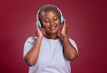 Image showing Black woman, headphones and smile for music listening, streaming or relax against a studio background. African American female with smile enjoying audio track, hifi or relaxing with wireless headset