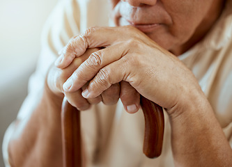 Image showing Hands of elderly man on walking stick, serious and sitting thinking, memories at retirement home. Grandpa with wooden cane, senior care for disability and nostalgia for sad lonely guy at nursing home