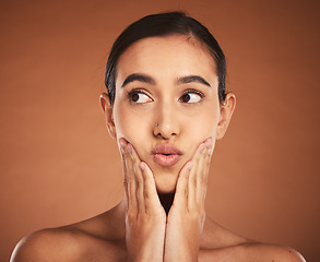 Image showing Woman with kiss lips, natural makeup on brown studio background and luxury skincare in dermatology spa. Latino girl with model pose, cosmetics beauty with lipstick and apply cream to face