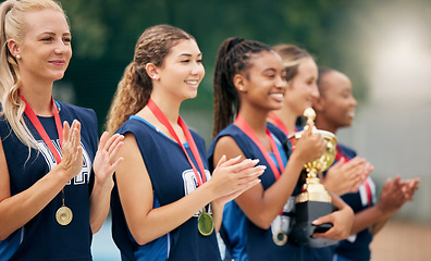 Image showing Netball team, clapping and medal, trophy and winner in sports competition, tournament and game outdoor. Teamwork, support and gold award for achievement, winner and celebration at sport event outdoor