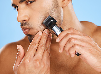 Image showing Beauty, skincare and man shaving beard in his grooming routine with an electric machine in a studio in Mexico. Wellness, Latino and healthy male model shaves his facial hair with a cool modern razor