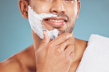 Image showing Man with shaving cream on face, beard maintenance and skincare for mens health and beauty treatment with blue background. Health, skin care and facial hair, morning shave bathroom routine with towel.