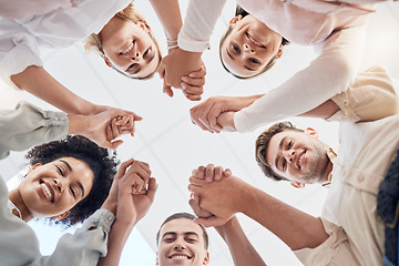 Image showing Teamwork, support and collaboration of happy employees with diversity, synergy and trust holding hands and looking down. Men and women team building circle for mental health mission in workplace