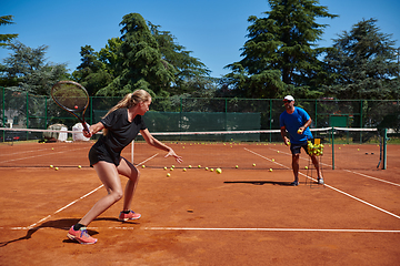 Image showing A professional tennis player and her coach training on a sunny day at the tennis court. Training and preparation of a professional tennis player