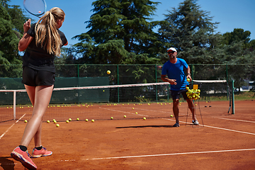 Image showing A professional tennis player and her coach training on a sunny day at the tennis court. Training and preparation of a professional tennis player