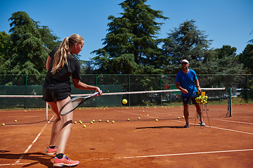 Image showing A professional tennis player and her coach training on a sunny day at the tennis court. Training and preparation of a professional tennis player