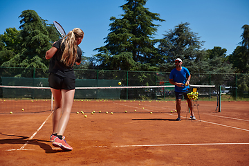 Image showing A professional tennis player and her coach training on a sunny day at the tennis court. Training and preparation of a professional tennis player