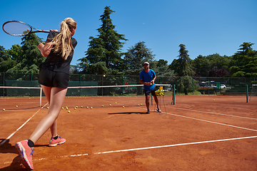 Image showing A professional tennis player and her coach training on a sunny day at the tennis court. Training and preparation of a professional tennis player