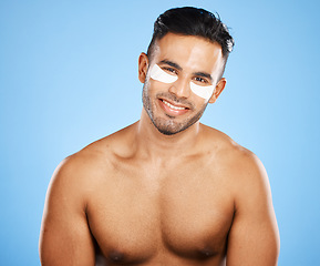 Image showing Man, skincare and eye care, cosmetic and grooming, eye mask and facial treatment portrait with blue studio background. Beauty, face and healthy skin, body wellness and cosmetology advertising.