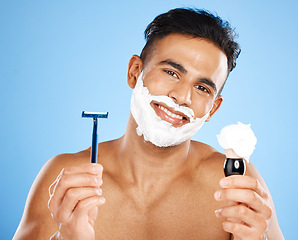 Image showing Man, razor and cream for skincare shaving, grooming or facial treatment against a blue studio background. Portrait of happy and satisfied male holding equipment for shave, beauty or clean hygiene