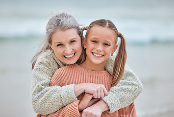 Image showing Hug, beach and portrait of girl and grandma on vacation, holiday or trip. Family love, care and happy grandmother bonding with kid, having fun and enjoying quality time together outdoors on seashore.