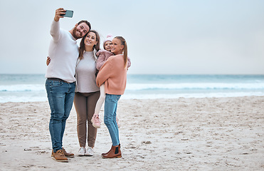 Image showing Beach, selfie and happy family smile, relax and bond at the ocean, hug and enjoy trip in nature together. Travel, phone and family picture at the sea while on vacation in Canada with girl and parents