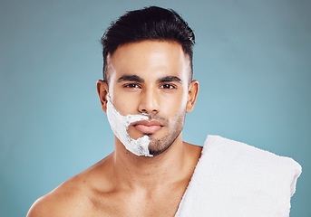 Image showing Shaving, beard and man with cream on his face for skincare against a blue mockup studio background. Wellness, health and portrait of a model with soap or foam to remove facial hair with mock up space