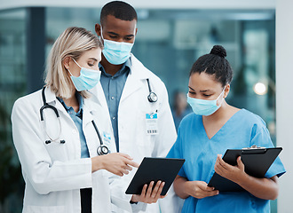 Image showing Doctor, tablet and covid team for healthcare, research or diagnosis in collaboration together at the hospital. Diverse group of medical professionals wearing masks looking at touchscreen in clinic