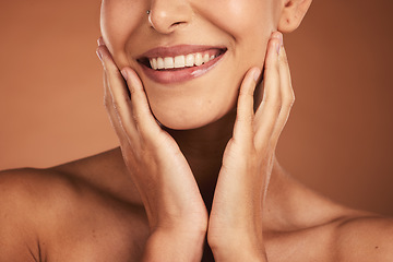 Image showing Dental, smile and teeth, oral care and woman on brown studio background. Health, wellness and closeup of female model with hands on face showing her natural looking veneers, healthy mouth and lips