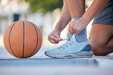 Image showing Basketball, sports and shoes with a man athlete tying his laces before a game on an outdoor court. Fitness, exercise and sport with a male basketball player fastening his shoelaces for a match