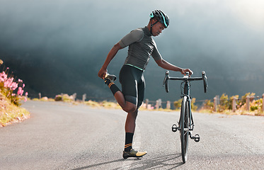 Image showing Black man, road and bicycle stretching, fitness or marathon training exercise, triathlon sports and outdoor cycling workout. Mountain bike athlete warm up body, cardio performance and balance focus