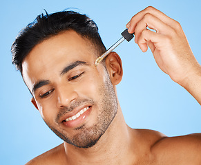 Image showing Beard oil, skincare serum and young man face makeup, hair growth product and wellness on blue background. Happy arab guy model drop essential oil, hyaluronic acid and body cosmetics for dermatology