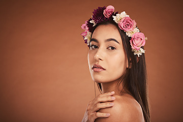 Image showing Makeup, beauty and woman with floral crown on head to model for cosmetics, beauty products and fashion. Creative, hair and artistic portrait of girl with flower headband on brown background studio