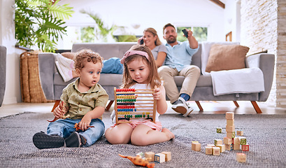 Image showing Development, family and children with math toys and playing with building blocks in the house living room. Education, mother and relaxed father watching tv with kids or siblings learning from a game