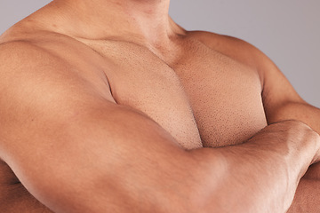 Image showing Body, muscle and bicep with a sports man standing arms crossed after exercise or fitness in studio on a gray background. Gym, motivation and workout with a shirtless male athlete posing for health