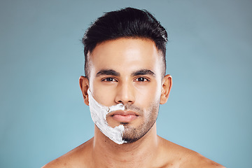 Image showing Shaving cream, face and portrait of man in a studio to shave his beard with foam or creme. Beauty, skincare and model from Puerto Rico grooming or cleaning his facial hair isolated by blue background