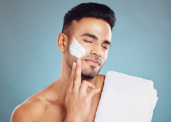 Image showing Face, skincare cream and man facial morning routine for beauty care. Young Indian person, hydrate skin treatment and grooming wellness or healthy dermatology bodycare in blue background studio