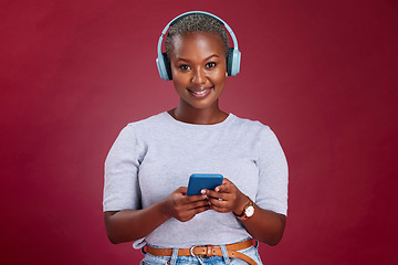 Image showing Happy black woman, phone or headphones for music, podcast or listening to radio in red studio background. Smile, wireless earphones of girl for relax audio, smartphone or social media networking