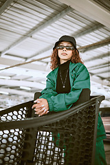 Image showing Shopping cart, sunglasses and stylish woman with fashion at a supermarket in the city of Tokyo. Urban, young and portrait of a fashion model shopping with designer, trendy and lifestyle clothes