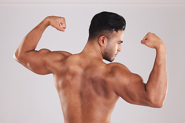 Image showing Muscle, bodybuilder and man flex, with natural body and confident with studio background. Muscular, young male and showing arms with pride, flexing and fitness for wellness, health and motivation.