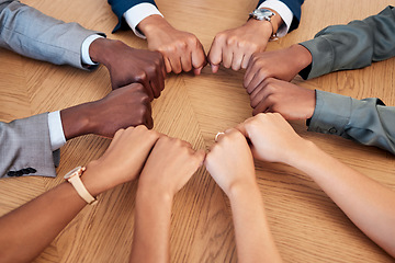 Image showing Diversity, teamwork and circle of hands in fist, aerial view for support, community and unity in workplace. Collaboration, agreement and business people working together in meeting with hand on desk