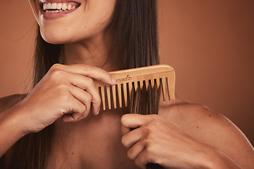 Image showing Woman combing hair, closeup smile and cosmetic face beauty for model with orange studio background. Hair care health, happy cosmetic girl and wood recycle comb for wellness with natural healthy locks