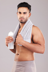 Image showing Portrait, water bottle and man with towel, for wellness and workout with grey studio background. Indian male focus, healthy trainer or exercise for fitness, training or motivation being relax or rest