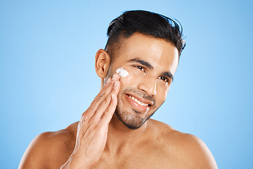 Image showing Man, beauty and skincare with smile for moisturizer, cream or facial treatment against a blue studio background. Happy male smiling in satisfaction for skin cosmetics, creme and care for hygiene