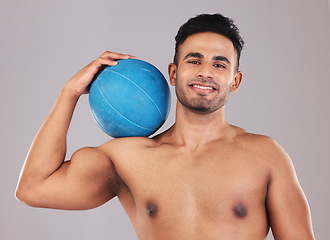 Image showing Health, fitness and medicine ball with a man athlete in studio on a gray background for exercise or training. Gym, wellness and workout with an athletic or strong male posing with sports equipment