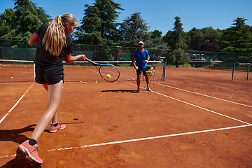 Image showing A professional tennis player and her coach training on a sunny day at the tennis court. Training and preparation of a professional tennis player