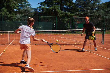 Image showing A professional tennis player and her coach training on a sunny day at the tennis court. Training and preparation of a professional tennis player