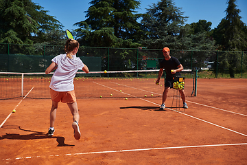 Image showing A professional tennis player and her coach training on a sunny day at the tennis court. Training and preparation of a professional tennis player