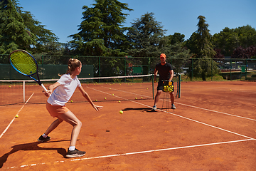 Image showing A professional tennis player and her coach training on a sunny day at the tennis court. Training and preparation of a professional tennis player