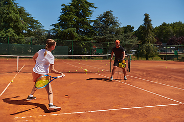 Image showing A professional tennis player and her coach training on a sunny day at the tennis court. Training and preparation of a professional tennis player