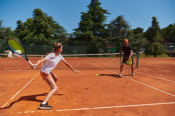 Image showing A professional tennis player and her coach training on a sunny day at the tennis court. Training and preparation of a professional tennis player