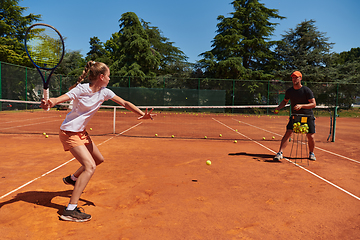 Image showing A professional tennis player and her coach training on a sunny day at the tennis court. Training and preparation of a professional tennis player