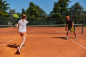 Image showing A professional tennis player and her coach training on a sunny day at the tennis court. Training and preparation of a professional tennis player